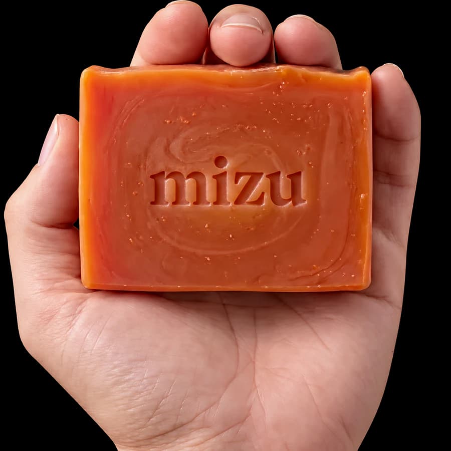 An orange Mizu soap bar resting in a hand